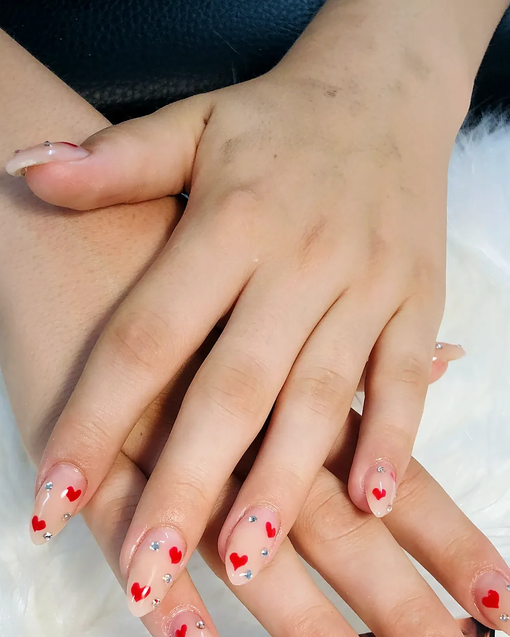 Nude Nägel mit kleinen roten Herzen